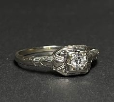 an antique diamond engagement ring with filigree accents