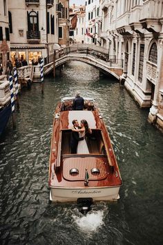 a man and woman in a boat on a canal