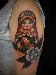 a woman's arm with a russian nesting doll on it