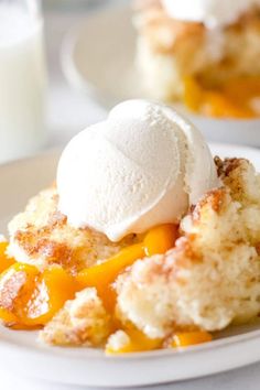 a piece of cake with ice cream on top is sitting on a white plate next to a glass of milk