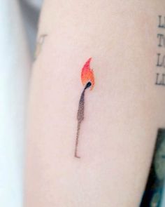 a small fire stick tattoo on the arm