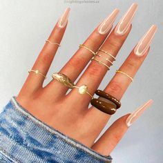 a woman's hand with five different rings on it and one ring in the middle