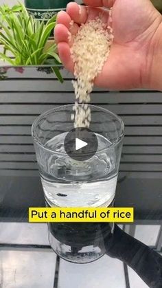 someone is pouring rice into a glass on top of a table with the words put a handful of rice in it