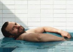 a man laying down in a swimming pool