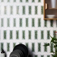 the wall is covered in green and white tiles, with plates stacked on top of each other