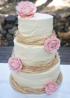 a three tiered cake with pink flowers on top