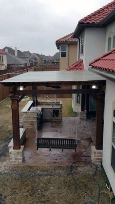 an outdoor kitchen and grill area in the back yard, with no one around it