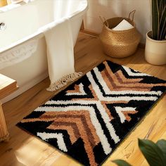 a bathroom with a bathtub, rug and plant in the corner on the floor