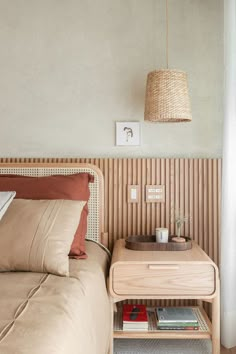 a bed sitting next to a nightstand with a lamp on it's headboard