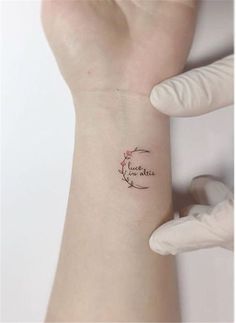 a woman's arm with a small tattoo on it