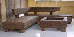 an old wooden bench and footstool in a room with tile flooring on the ground