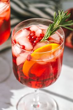 a close up of a drink in a glass with ice and garnishes