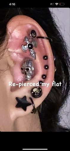 a woman with black and silver piercings on her ear