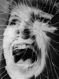 a woman's face is shown through a cracked glass window with her mouth open