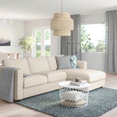 a living room filled with white furniture and lots of windows