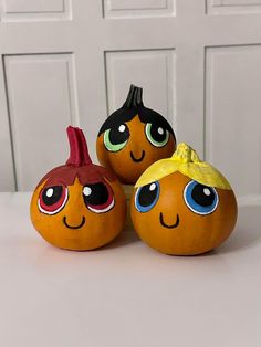 three pumpkins with faces painted on them