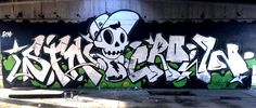 graffiti on the side of a building with green and white letters that read, skull