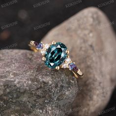 a ring with an oval blue topaz surrounded by small white and purple diamonds on a rock