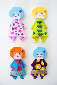 three paper dolls are hanging on the wall