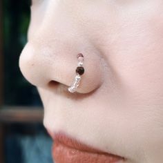 a close up of a person's nose with a nose ring attached to it