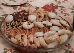 a glass bowl filled with lots of different types of pastries on top of a table