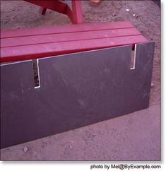 a red bench sitting on top of a dirt field