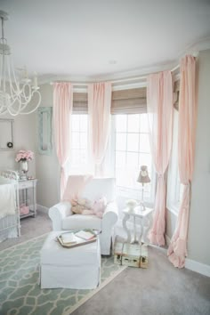 a baby's room with pink curtains and white furniture