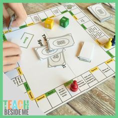 a person playing a board game on a wooden table with dices and markers in front of them