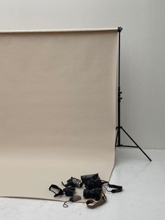 an empty photo studio with equipment on the floor and behind it is a white backdrop