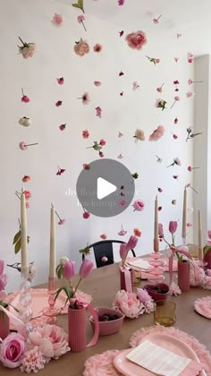 the table is set with pink flowers and candles