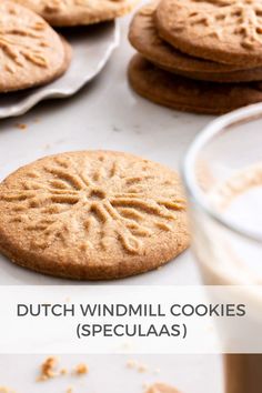 some cookies and milk on a table with the words dutch windmill cookies spelled in english