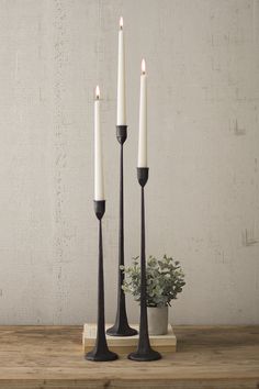 three candles are sitting on a wooden table