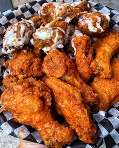 a basket filled with fried food on top of a checkered tablecloth covered plate