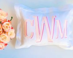 a bouquet of roses next to a pillow with the word cvwm on it