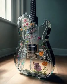 an electric guitar with flowers painted on it's body sitting in front of a window