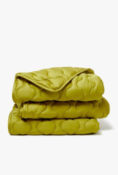 two blankets folded on top of each other in bright lime green color, with the covers rolled down