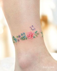 a woman's foot with flowers and butterflies on it