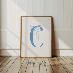 a wooden floor with a framed photograph on it and the letter c in blue ink