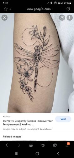 a woman's thigh with flowers and a dragonfly tattoo on it