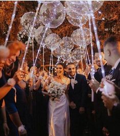 a bride and groom walk down the aisle with their guests holding sparkler wands