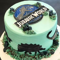 a birthday cake decorated with an image of a dinosaur and the words jurassic world on it