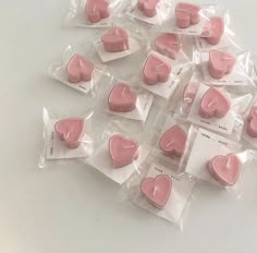 there are many small pink hearts in plastic bags