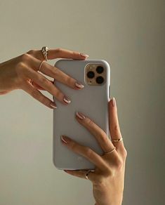 two hands holding an iphone case in front of their face and one hand on the phone