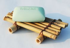 a soap bar sitting on top of some bamboo sticks with the word palmolive written on it