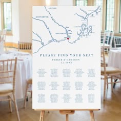 the seating map for this wedding is displayed on an easel in front of tables and chairs