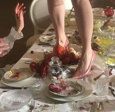 two people standing over a table with plates and silverware