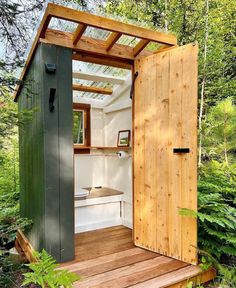 an outhouse in the woods with wooden steps leading up to it's door