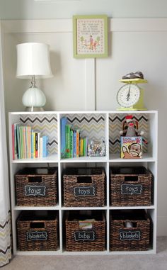 a white shelf with baskets and books on it