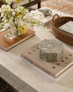 a table topped with books and flowers on top of a white marble slabd counter