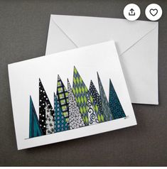 two greeting cards, one with an image of trees on it and the other has a white envelope